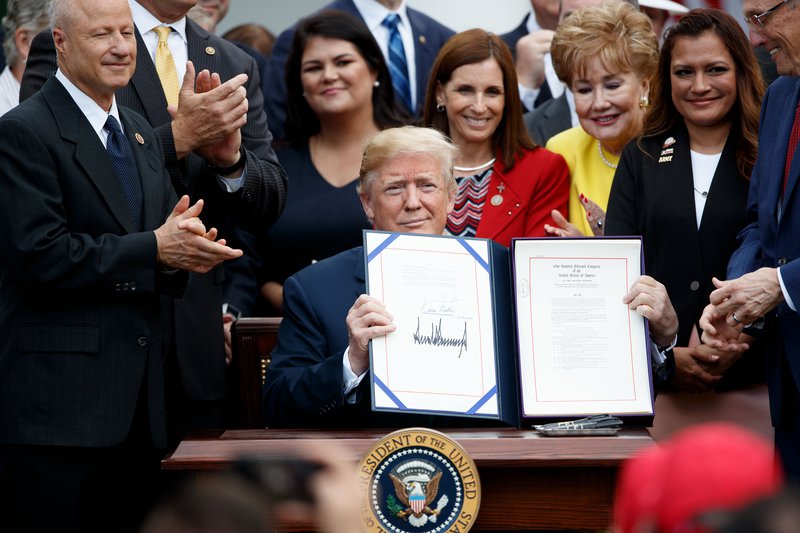 Donald Trump holds up a file that bears his signature