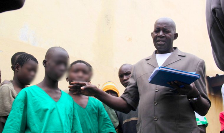 A man standing beside children in green clothing