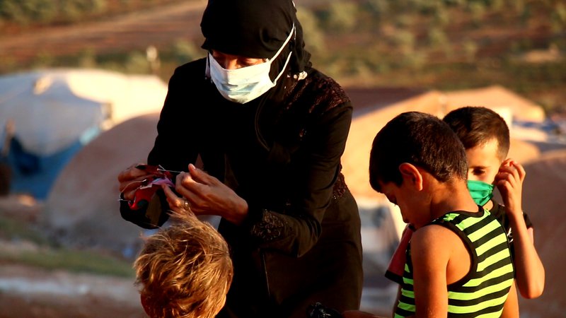 سيدة تحيك كمامات لأطفالها في مخيم _سنجار كهربا_ قرب سرمدا تصوير جابر عويد (خاصة)(1).jpg